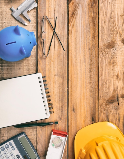 Photo budget des coûts de construction du projet vue de dessus de la calculatrice de tirelire et de l'équipement d'ingénierie sur un espace de copie de bureau en bois