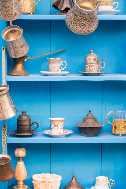 Buffet en bois bleu avec des plats orientaux antiques pour le thé et le café