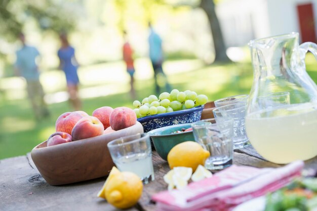 Un buffet d'été de fruits et légumes disposés sur une table Personnes en arrière-plan