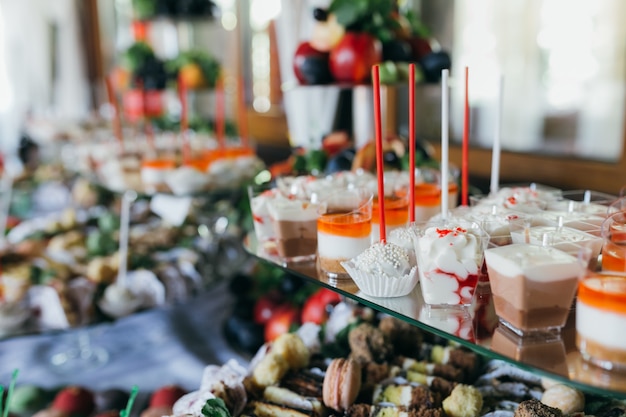 Buffet de mariage sucré avec différents desserts et fruits.