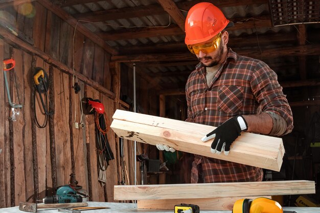 Builder man porte des planches sur son épaule