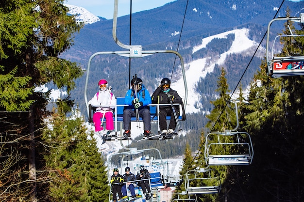 BUKOVEL, UKRAINE - 10 février 2019 : personnes aux remontées mécaniques dans les montagnes. activité de sports d'hiver