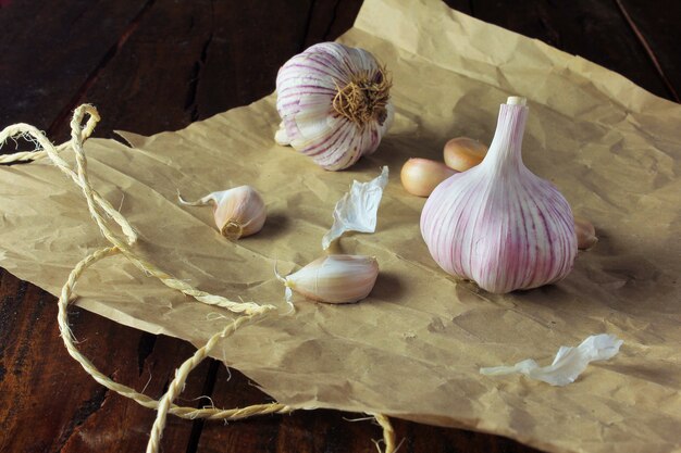 Bulbes d&#39;ail sur du papier d&#39;emballage, sur une table en bois rustique