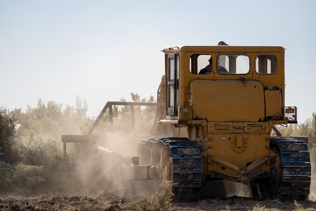 Photo un bulldozer nettoie le sol pour faire un quartier résidentiel.