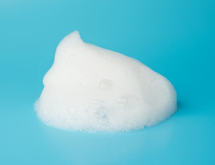 Photo bulle de mousse de savon isolée sur bleu
