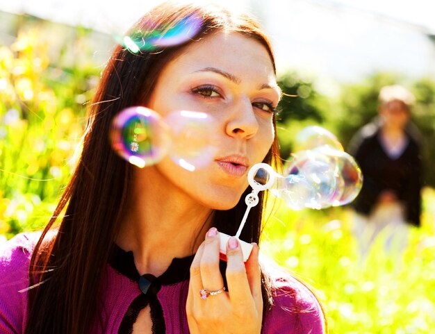 Bulle de savon fille contre une herbe de fond