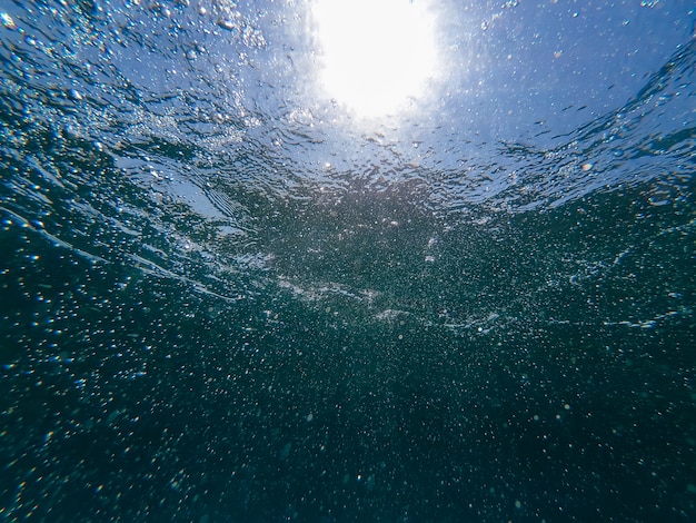 bulles d'air dans l'eau bleue de la surface de la mer sous l'eau