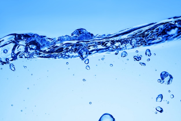 Bulles d'air sous l'eau bleue et vagues ou éclaboussures