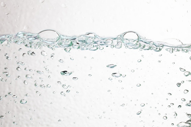 Bulles De Gros Plan Sous L'eau Sur Une Surface Blanche.