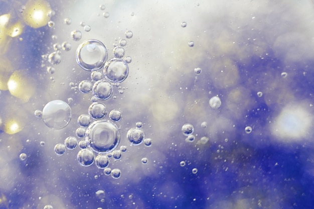 Les bulles d'huile se bouchent. une macro de cercles d'eau. abstrait bleu clair