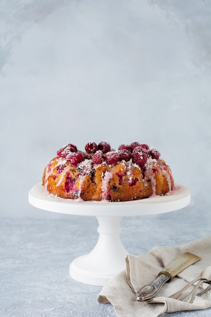 Bundt-cake au citron avec des framboises sur une lumière.