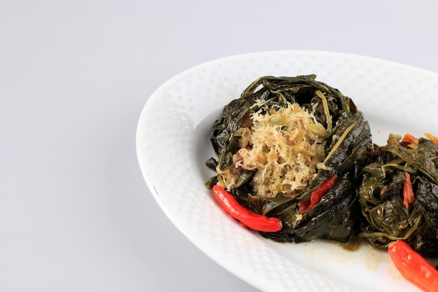 Photo buntil est un aliment traditionnel indonésien à base de feuilles de papaye/manioc farcies de noix de coco râpée, de petai cina et d'anchois. populaire dans la cuisine javanaise et sundaise, copy space