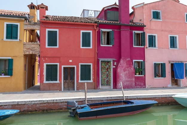 Burano, Venise, Italie - 2 juillet 2018 : Vue panoramique sur les maisons aux couleurs vives et le canal d'eau avec des bateaux à Burano, c'est une île de la lagune de Venise. Les gens marchent et se reposent dans les rues