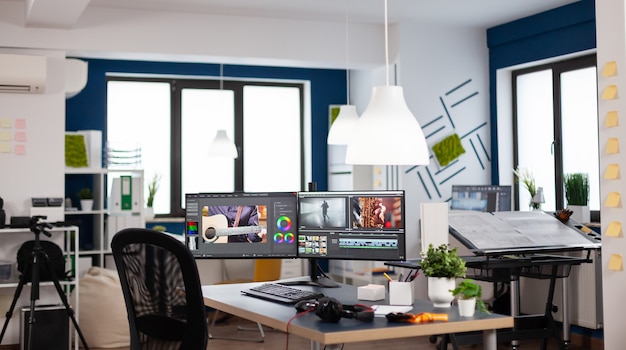 Bureau d'agence de création moderne vide avec configuration de deux moniteurs avec traitement de montage de film vidéo