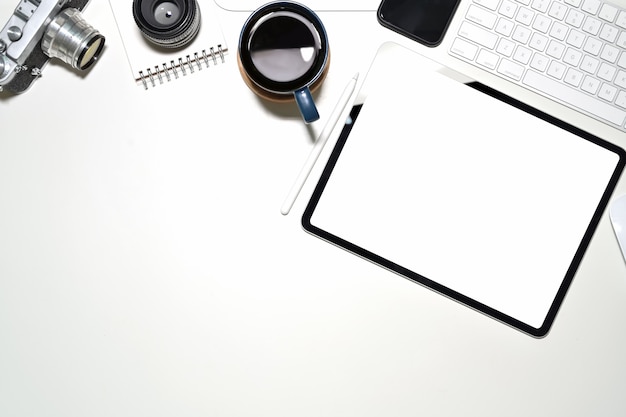 Bureau blanc avec tablette à écran blanc, appareil photo vintage, tasse à café et espace de copie