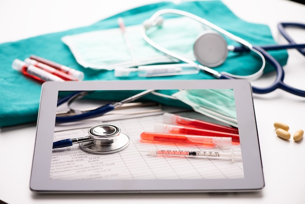 Bureau de centre de santé blanc avec tablette avec titre de coronavirus et fournitures médicales et de bureau. Fermer