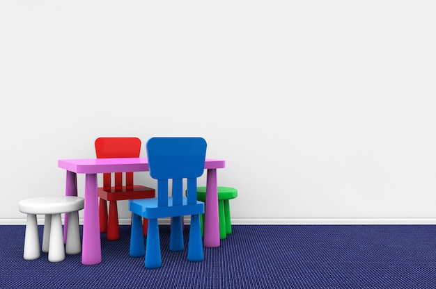 Bureau et chaises d'enfants contre un mur blanc