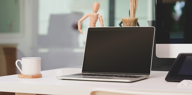 Bureau confortable avec ordinateur portable à écran blanc ouvert