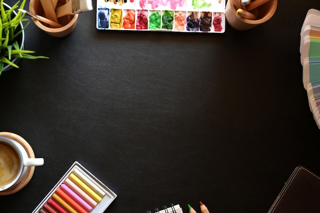 Bureau en cuir d&#39;artiste avec fournitures créatives et espace de copie.