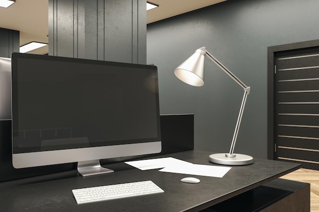 Bureau design avec écran d'ordinateur noir et lampe