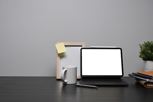 Bureau à domicile avec cadre photo pour tablette d'ordinateur et tasse à café sur tableau noir