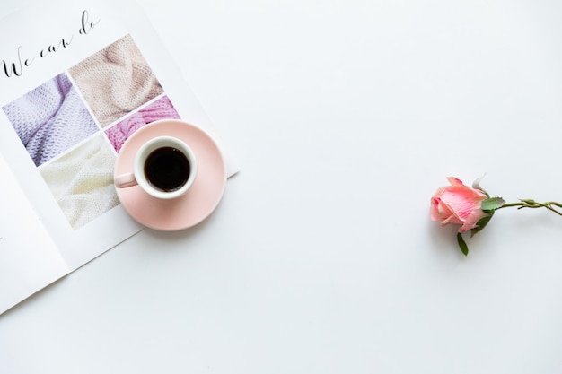 Bureau à domicile moderne et féminin avec des lunettes de cahier rose pastel tasse de café fleurs sauvages