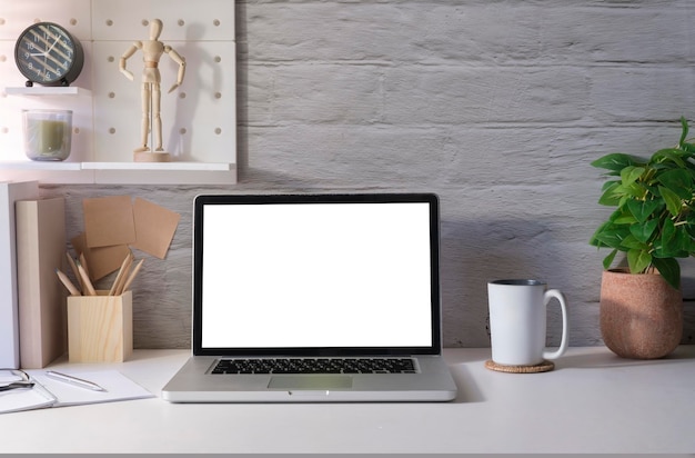 Bureau à domicile moderne et lumineux avec fournitures pour ordinateur portable et pot de fleurs sur tableau blanc Écran vide pour votre texte publicitaire