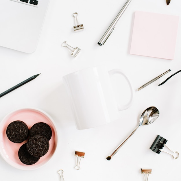 Bureau à domicile avec tasse blanche propre, biscuits, ordinateur portable, cuillère et accessoires