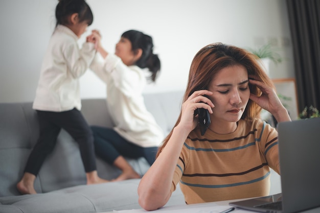 Bureau à domicile. Travail à domicile vs maman avec deux enfants Travaillez sur Internet sur un ordinateur portable à la maison. quarantaine. Corona virus.