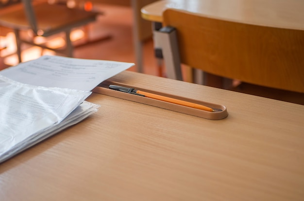 Bureau d'école avec des papiers et un crayon