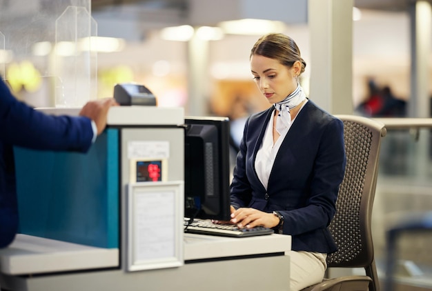 Bureau d'enregistrement à l'aéroport et femme tapant pour l'identité de sécurité et les documents de voyage pour le service d'immigration à la frontière Conciergerie service client et aide pour le transport mondial avec pc sur table