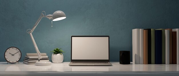 Bureau ou espace de travail moderne et élégant avec maquette d'éboulis pour ordinateur portable sur une table blanche sur un mur bleu