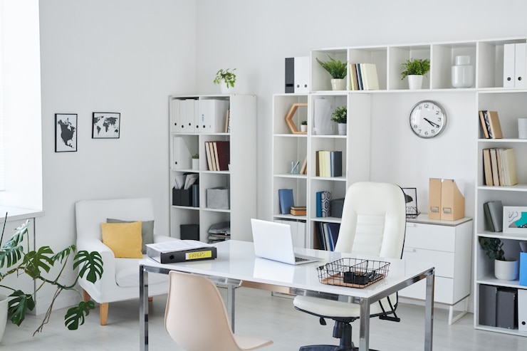 Photo bureau d'homme d'affaires avec bureau, fauteuil de professionnel, chaise pour clients, étagères, horloge, plante verte et deux photos sur le mur