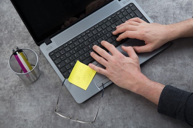 bureau avec mains sur ordinateur portable