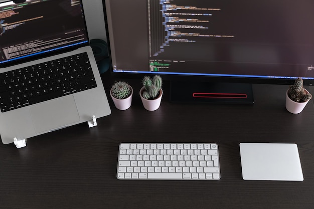 Photo bureau avec moniteur d'ordinateur portable, clavier et trackpad avec logiciel de code, bureau à domicile ouvert