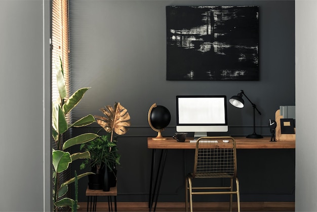 Un bureau noir et or avec un écran blanc et une plante dessus.