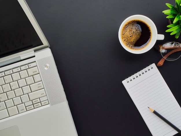 Bureau noir avec ordinateur portable.