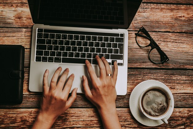 bureau avec ordinateur portable, verres et une tasse de café