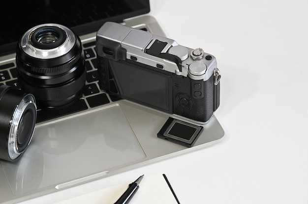 Photo bureau de photographe avec appareil photo, objectif, ordinateur portable et mémoire.