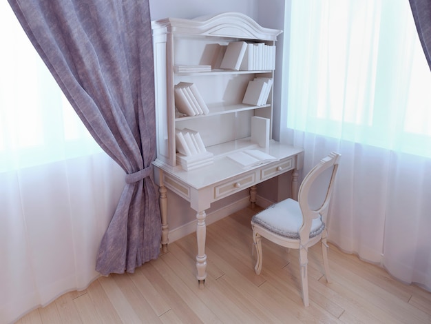 Bureau simple près de la fenêtre dans une chambre de style classique pour enfants aux couleurs violettes