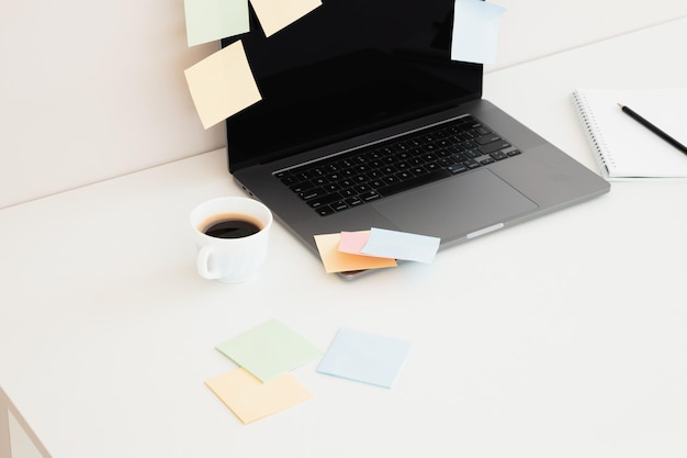 Bureau avec sticky noteordinateur portable crayon et tasse de café sur fond de table en bois blanc