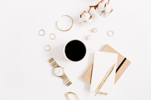 Bureau de style or de blog de mode avec collection d'accessoires femme: montres dorées, ciseaux, tasse à café, cahier et branche de coton sur blanc