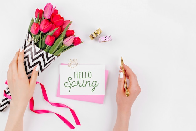 Bureau de style rose et or avec des fleurs. Les mains des femmes tiennent des fleurs