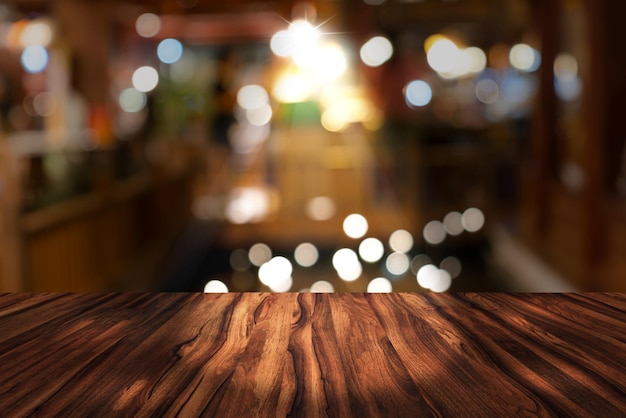 Photo bureau supérieur avec fond de restaurant flou table en bois et bokeh flou de fond de rue de nuit
