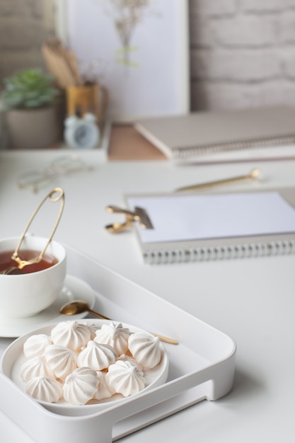 Bureau avec une tasse de thé et des guimauves