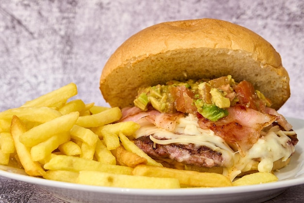 Un burger accompagné de frites dans une assiette