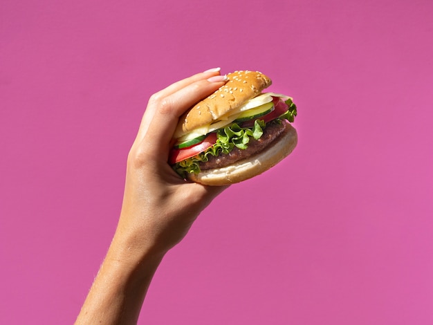 Burger américain avec de la laitue sur fond rose