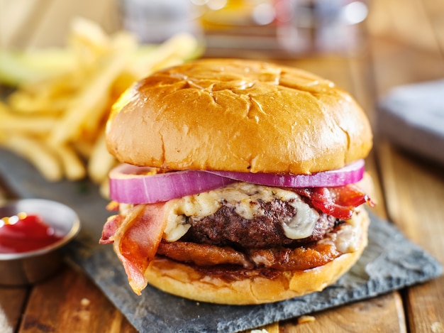 Burger au bacon à l'occidentale avec rondelles d'oignon et sauce barbecue