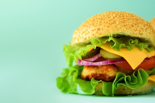 Burger au fromage fait maison ou hamburger sur fond bleu avec espace de copie. Restauration rapide au petit-déjeuner et au déjeuner.