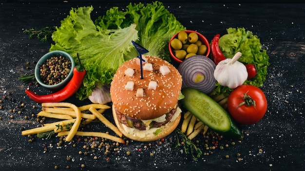 Burger au fromage de veau saindoux et de la laitue Cuisine traditionnelle américaine sur un fond de bois noir Copy space